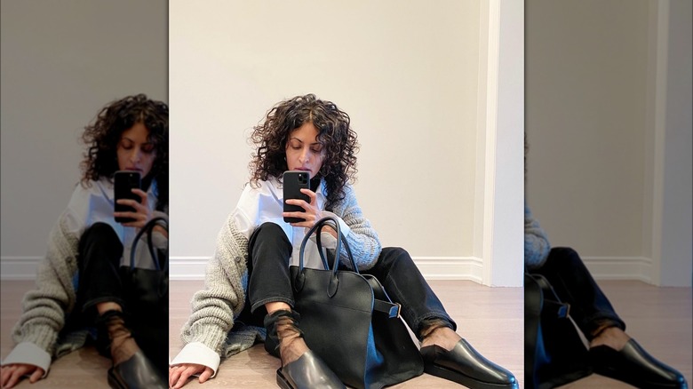 Woman with a plain black tote.