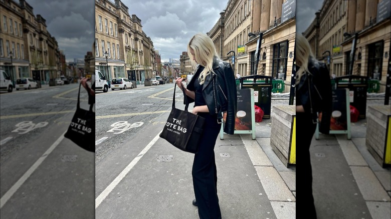 Woman carrying a Marc Jacobs tote bag.