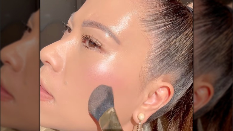 woman applying powder blush