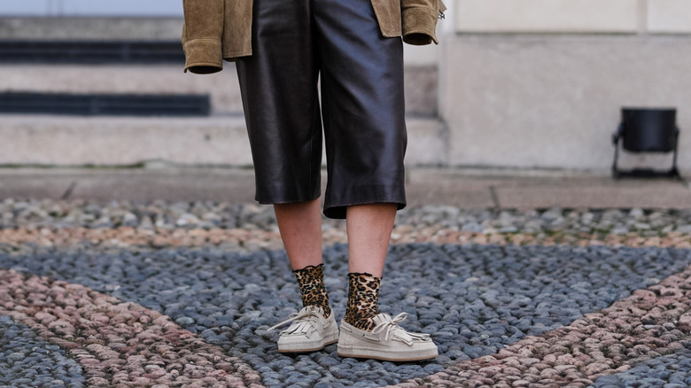 Woman wearing pink sweater and brown suede coat
