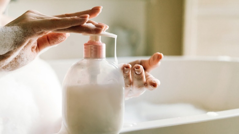 Hand pressing a body wash dispenser