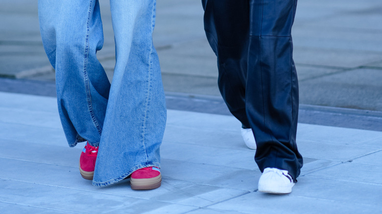 A woman wearing red sneakers with a friend in white sneakers