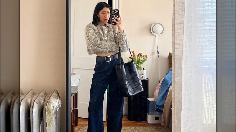 Woman carrying black woven bucket bag