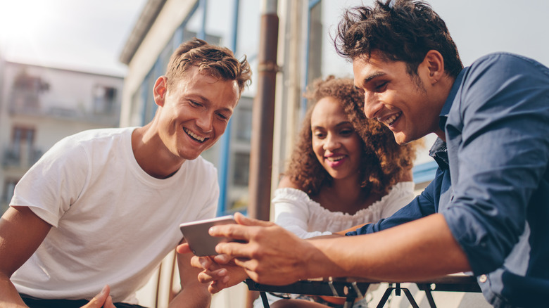 three friends looking at phone
