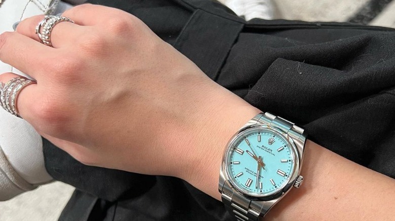 Woman models silver watch with silver rings