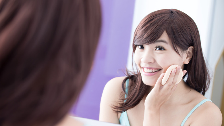 person putting on foundation