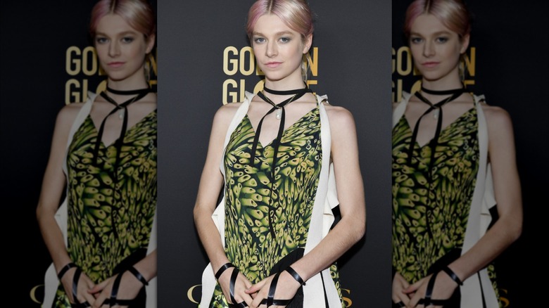 Hunter Schafer on the red carpet in a patterned green dress