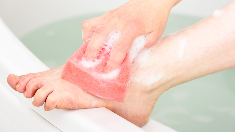 woman washing feet in bathtub
