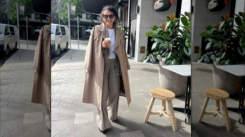 Woman wearing a trench coat draped over the shoulders.