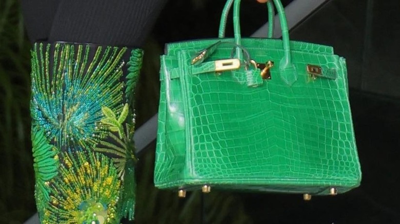 woman holding crocodile print handbag