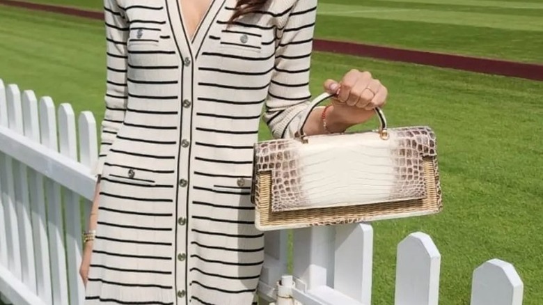 woman holding crocodile print handbag