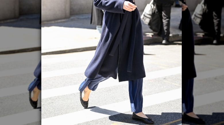 A woman wearing black almond-toe flats with jeans