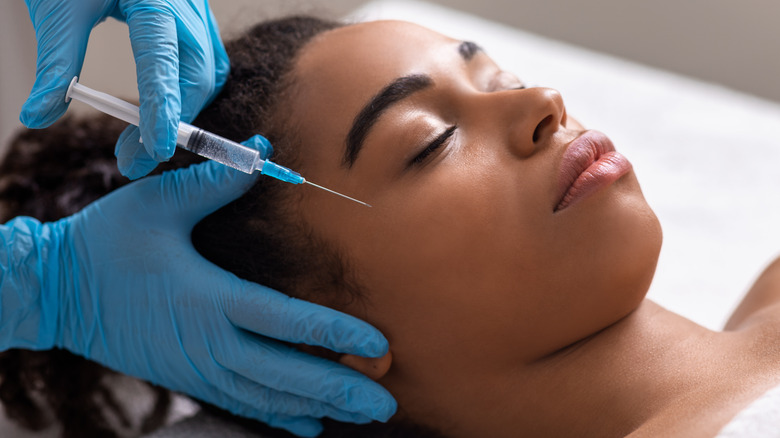 Woman getting dermal filler injected