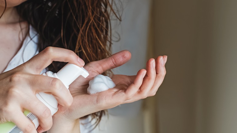 woman pumping volumizing mousse 