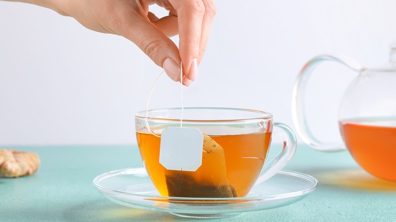 woman removing teabag from tea