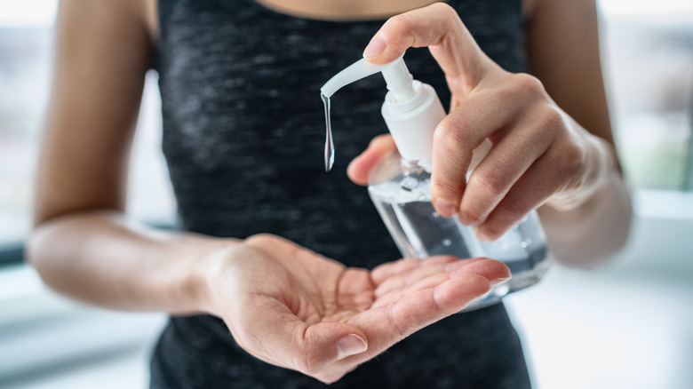 woman applying hand sanitizer