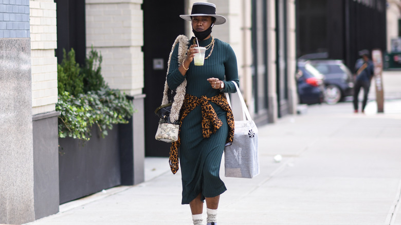 Woman ties sweater over dress