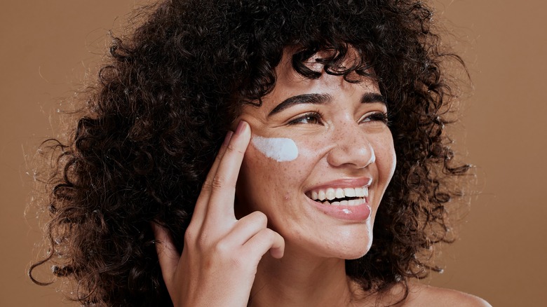 woman putting on sunscreen