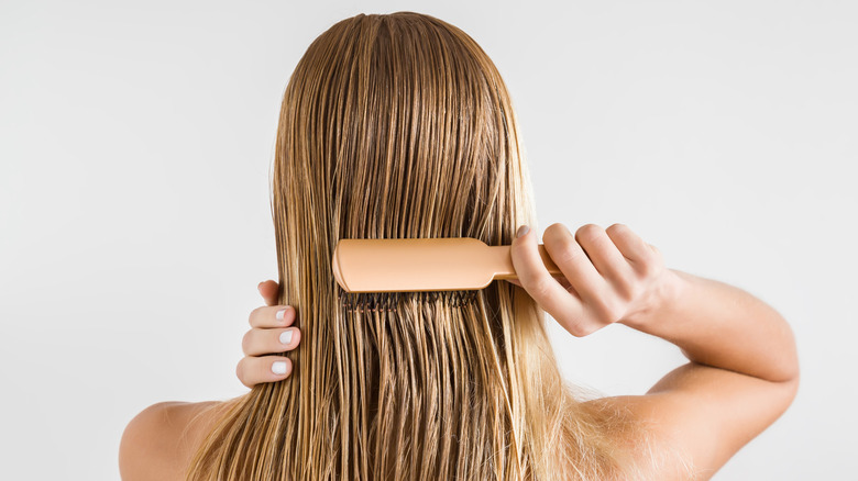 woman combing hair in shower