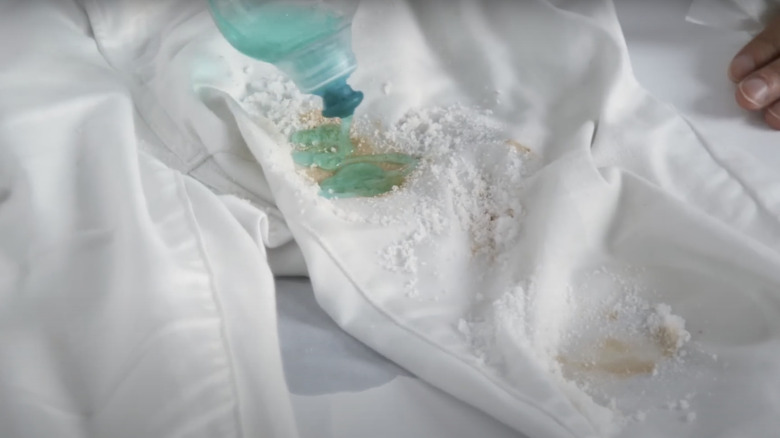 person pouring detergent on jeans