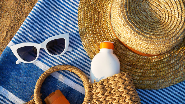 Flat lay of sunglasses, hat, and beach bag