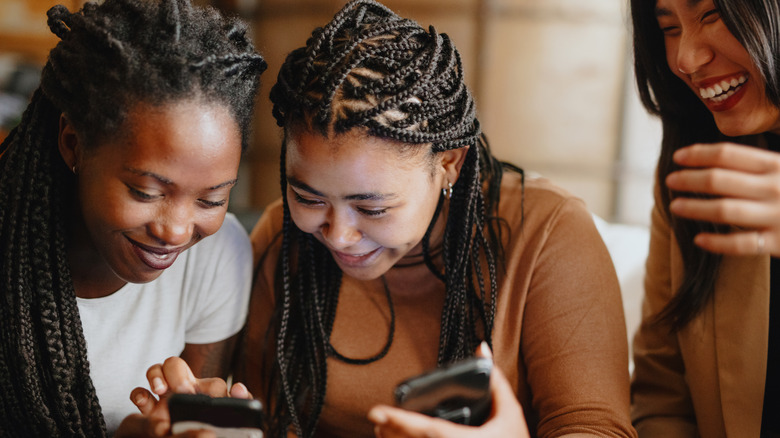 Three women using their smartphones
