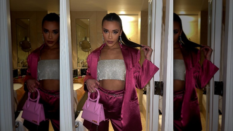 Influencer wearing a pink pantsuit with accessories.