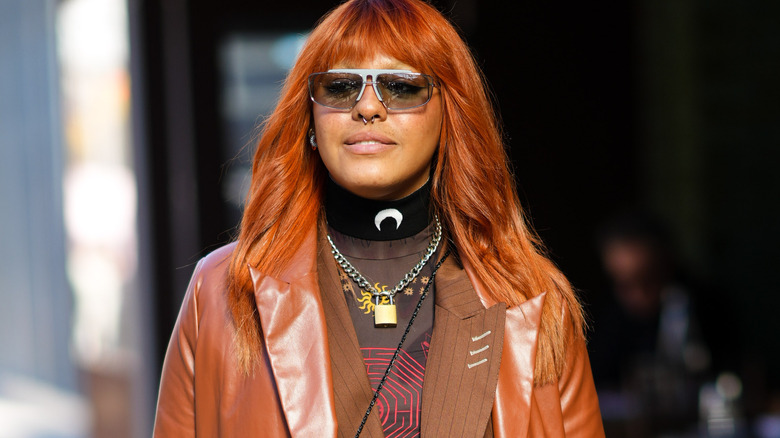 Woman wearing gold and silver lock necklace.