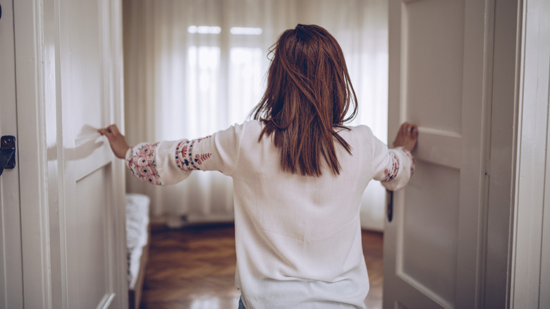 woman opening bedroom door
