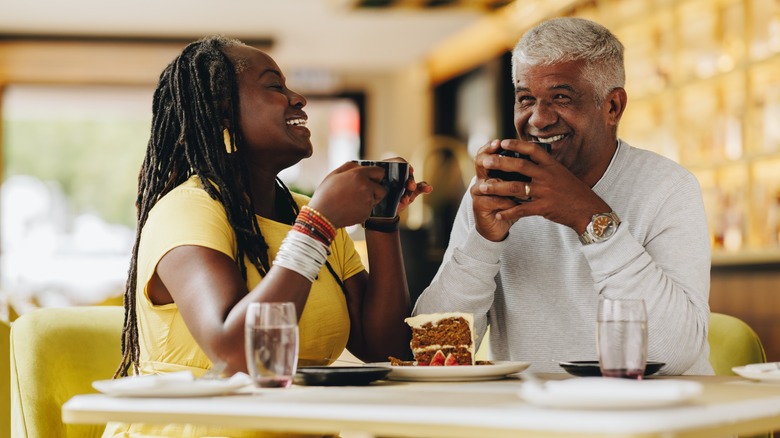 couple drinking coffee and sharing cake in restaurant