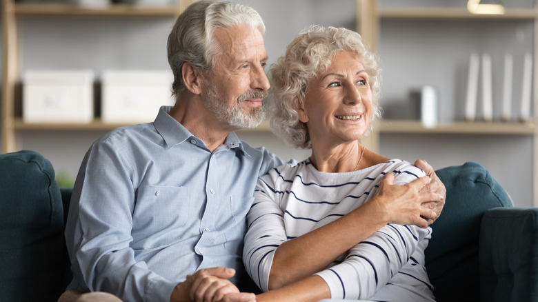 older couple embracing and looking outside