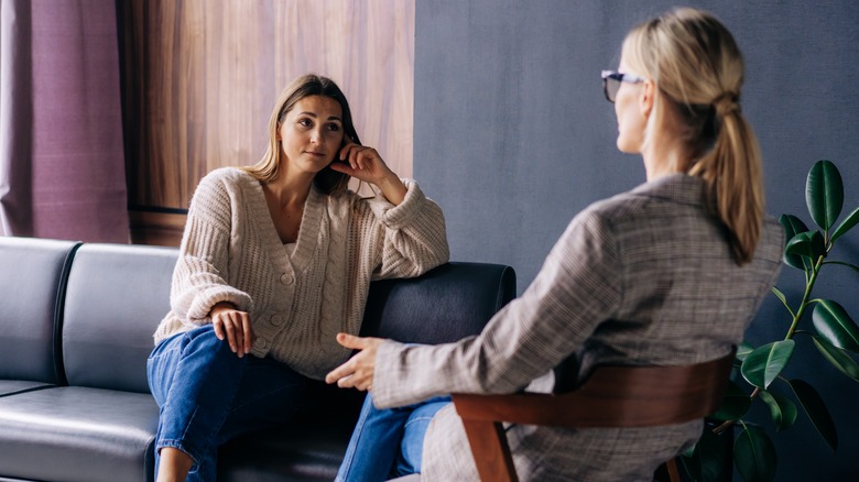 Two women sitting across from each other discussing