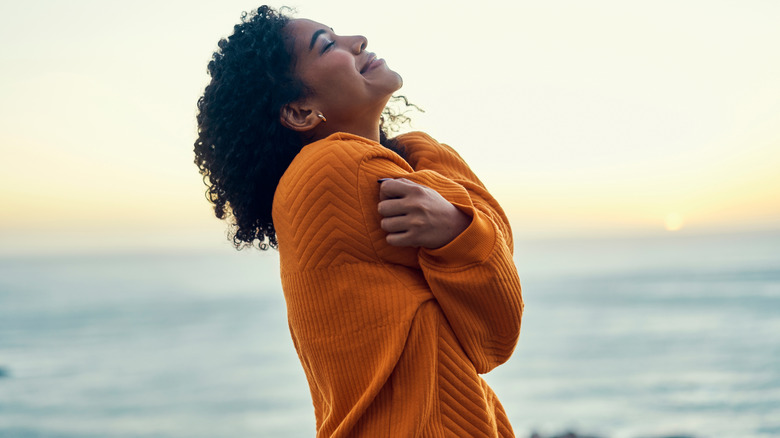 Woman hugging herself outside