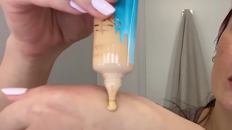 woman applying tinted moisturizer 