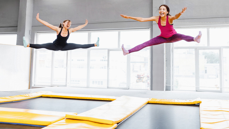Women doing splits above trampoline