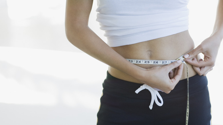 Woman measuring her waist