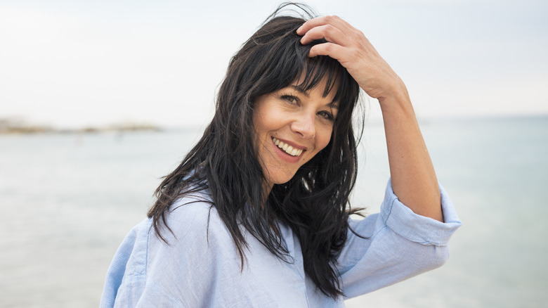 Woman with long hair and bangs smiles