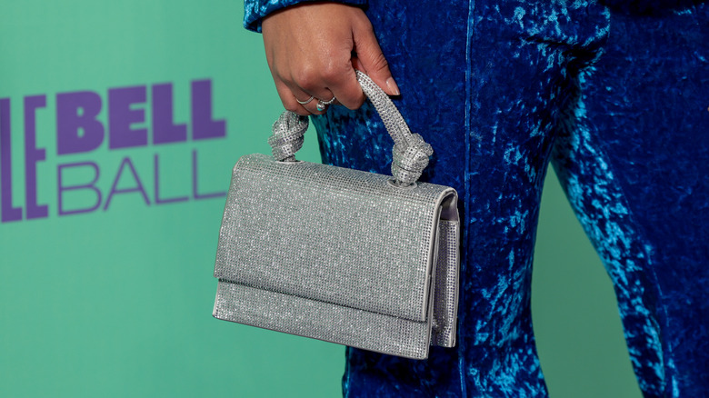 woman carrying silver handbag