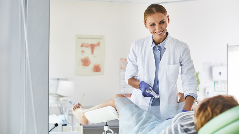 Gynecologist holds speculum 