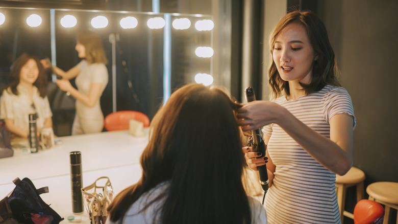 hair dresser curling client's hair