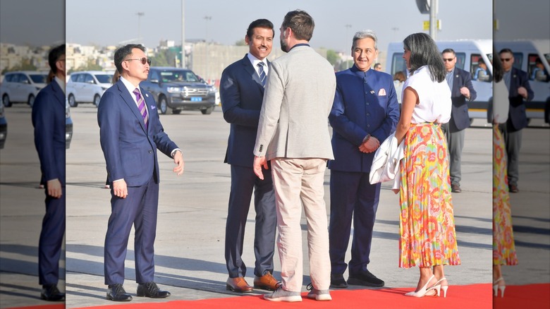 Usha Vance wearing a white shirt and colorful skirt while greeting officials in India