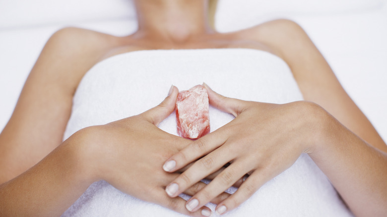 Woman holds crystal sacral chakra 