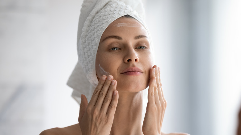 woman washing face in bath towel