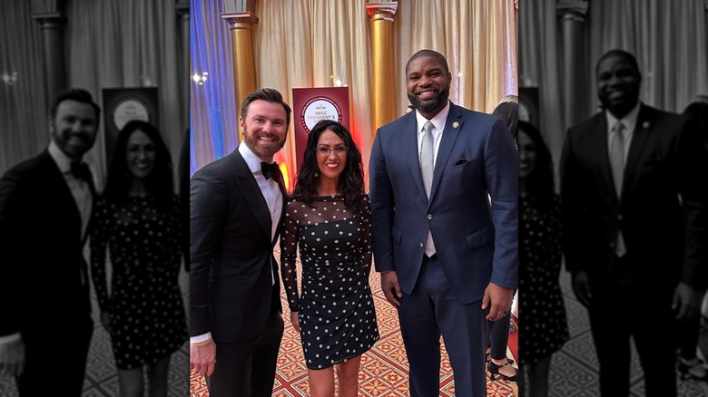 Lauren Boebert smiles in a black and white polka dot dress while taking a picture with attendees at the National Republican Congressional Committee gala