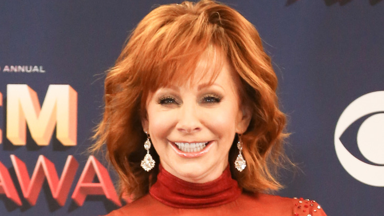 Reba McEntire on the red carpet in a red dress