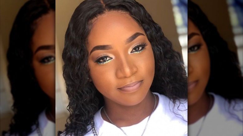 Black woman wearing teal glitter