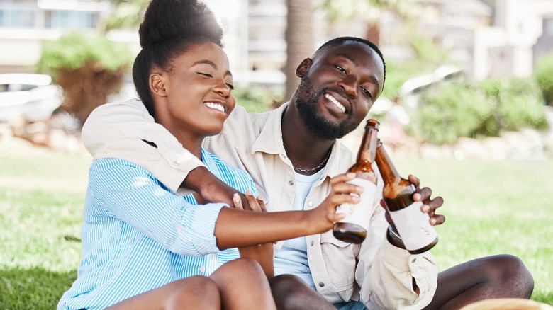 couple drinking beer in park