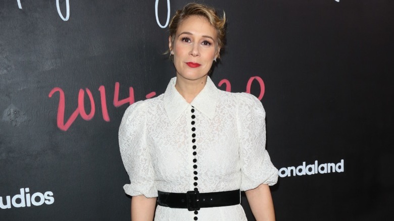 Liza Weil wearing a white dress with black detailing on a red carpet in 2020.