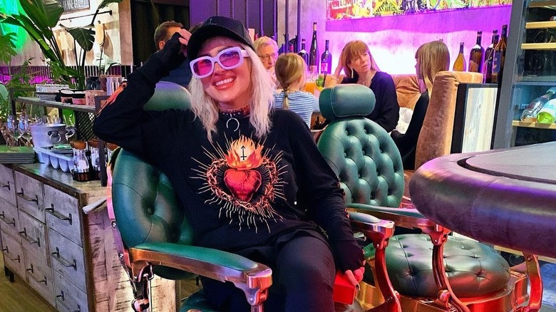 Girl wearing lavender sunglasses inside