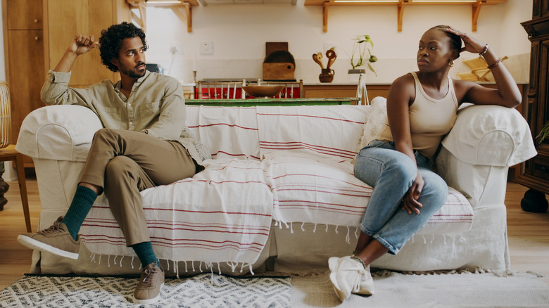 couple sitting in tension on couch 